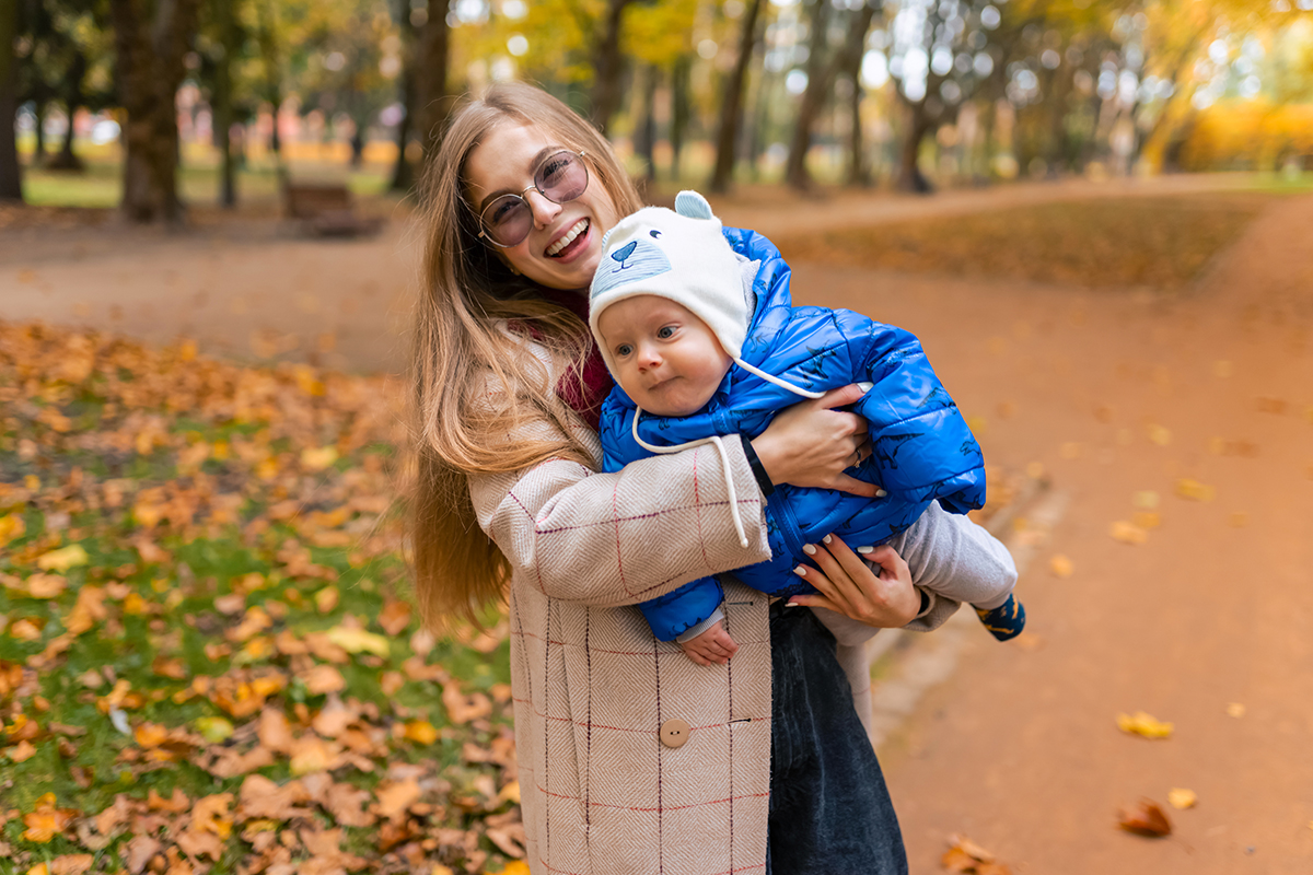 Happiness mom with baby in hands in the park Airbnb Single Mom